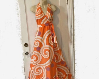 May include: A long orange and white halter dress with a swirl pattern and purple polka dots. The dress has a ruffled hem and a tie at the waist.