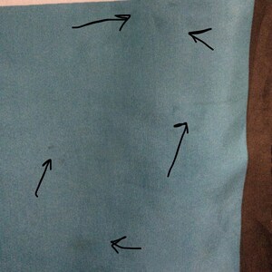 May include: Close-up of a section of fabric with horizontal stripes in teal, white, and pink. The fabric has a subtle texture and appears to be a soft material. The image is well-lit, highlighting the colors and texture.