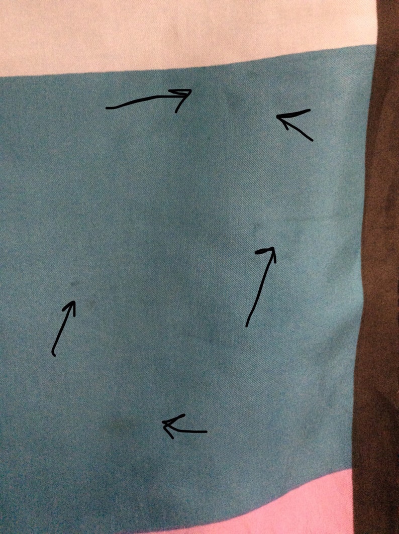 May include: Close-up of a section of fabric with horizontal stripes in teal, white, and pink. The fabric has a subtle texture and appears to be a soft material. The image is well-lit, highlighting the colors and texture.