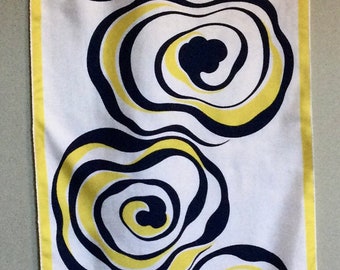 May include: A white silk scarf with a yellow border and a repeating pattern of black and yellow concentric circles. The scarf is signed "Nina Ricci Paris".