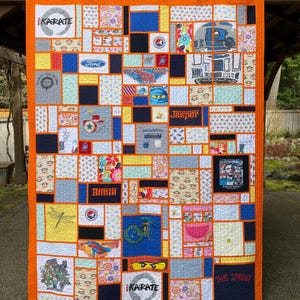 May include: A rectangular memory quilt featuring a vibrant orange border and a patchwork design of various fabric squares. The quilt includes printed graphics such as the word Karate, a Ford logo, R2-D2, the name Jasper, and Barack Obama.