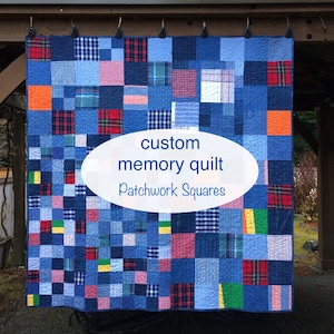 May include: A patchwork quilt composed of numerous square fabric pieces in various shades of blue, red, green, and orange, featuring plaid, checkered, and solid patterns. The text "custom memory quilt Patchwork Squares" is centered on the quilt.