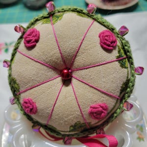 Machine Embroidered pin cushion with hand crocheted bottom and han embroidered bullion roses