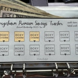 May include: A white and black printable savings tracker for Boxycharm subscriptions. The tracker has 12 boxes with the text "BOXY CHARM" and a heart symbol. The text "each box $36 total amt: $432" is printed at the top of the tracker.