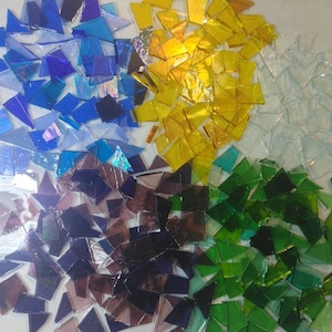 Puede incluir: Composici&oacute;n abstracta de fragmentos de vidrio de colores. La imagen presenta grupos de trozos de vidrio azules, amarillos, blancos, verdes y morados. El texto "debscolorfulcorner" est&aacute; en la esquina inferior derecha.