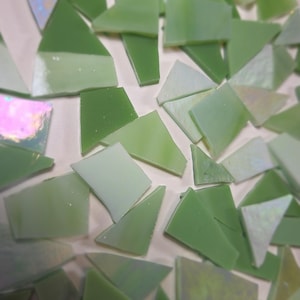 May include: A collection of irregular, angular glass mosaic tiles in various shades of light and dark green. Some pieces feature a translucent, iridescent finish that reflects light. The text Debscolorfulcorner.etsy.com is visible at the bottom.