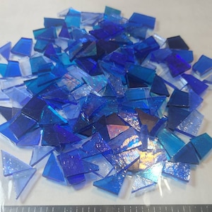 Puede incluir: Un conjunto de peque&ntilde;os trozos de vidrio azul de diferentes tonos. Una regla negra con medidas en cent&iacute;metros est&aacute; en primer plano. El texto "debscolorfulcorner" es visible en la esquina inferior derecha.