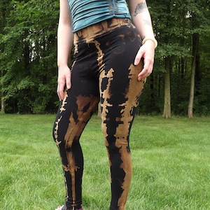 May include: Black leggings with a brown tie-dye pattern. The leggings are fitted and have a high waist.