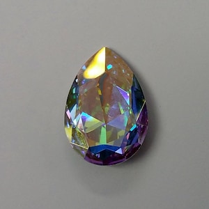 Peut inclure: Un cristal iridescent en forme de larme avec un arc-en-ciel de couleurs, y compris le violet, le bleu, le vert et l'or.
