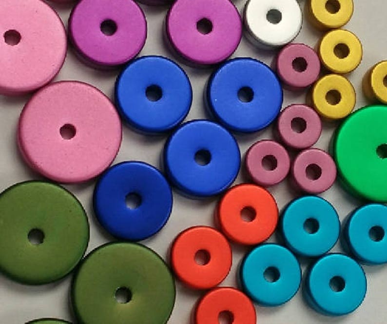 May include: Assortment of colorful round wooden beads with a hole in the center. The beads are in various colors, including pink, blue, green, red, and yellow.