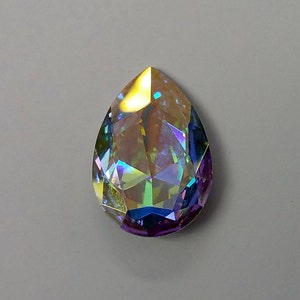 Peut inclure: Un cristal iridescent en forme de larme avec un arc-en-ciel de couleurs, y compris le violet, le bleu, le vert et l'or.