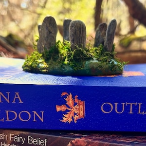 May include: A set of three ceramic mugs with a speckled, matte finish. The mugs are in shades of cream, light gray, and dark gray. Each mug has a simple, minimalist design, perfect for coffee or tea.