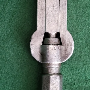 May include: A silver adjustable wrench with a textured surface. The wrench has a fixed handle and a movable jaw.