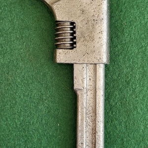 May include: A silver adjustable wrench with a  "STILLSON" logo on the top. The wrench has a  adjustable jaw and a  handle with a  smooth finish.
