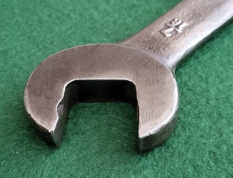 K&ouml;nnte beinhalten: Nahaufnahme eines silbernen Schraubenschl&uuml;ssels mit einer abgerundeten &Ouml;ffnung. Der Schraubenschl&uuml;ssel hat die Nummer "24" auf dem Griff.