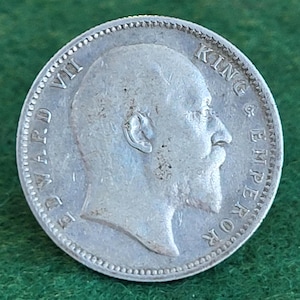 May include: Silver coin featuring a profile portrait of King Edward VII, with the inscription "KING & EMPEROR" around the edge.