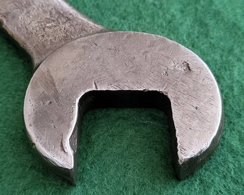 K&ouml;nnte beinhalten: Nahaufnahme eines silbernen Schraubenschl&uuml;ssels mit abgerundetem Kopf und einer quadratischen &Ouml;ffnung. Der Schraubenschl&uuml;ssel hat ein abgenutztes, gebrauchtes Aussehen.