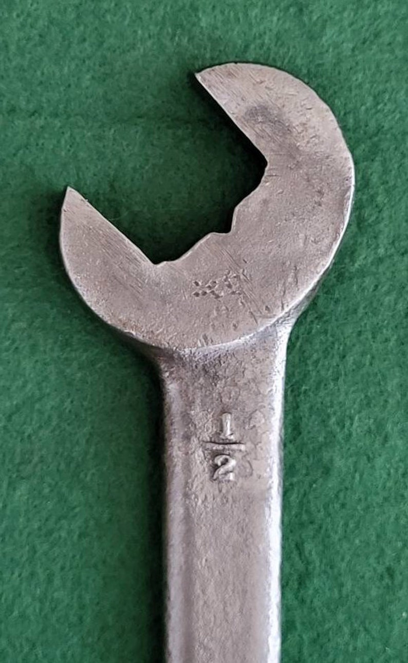 K&ouml;nnte beinhalten: Ein silberner Schraubenschl&uuml;ssel mit einer Gr&ouml;&szlig;enmarkierung von 1/2 Zoll. Der Schraubenschl&uuml;ssel hat einen abgerundeten Kopf und einen langen Griff.