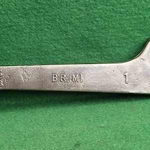May include: A silver wrench with a 5/8 inch opening and a 1 inch opening. The wrench is labeled "BR(M)".