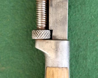 Puede incluir: Llave inglesa ajustable vintage con cuerpo de metal y mango de madera. La llave tiene un mecanismo de tornillo para ajustar el tamaño de la mordaza. El texto "THE LAMSON & SESSIONS CO. CASE HARDENED CLEVELAND" es visible.