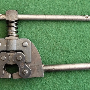 Puede incluir: Una herramienta de cadena de metal vintage con acabado negro y mango plateado. La herramienta tiene una etiqueta que dice "Made in England".