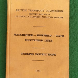 May include: A vintage booklet with a tan cover. The cover features the text "BRITISH TRANSPORT COMMISSION", "BRITISH RAILWAYS", and "EASTERN AND LONDON MIDLAND REGIONS". Below, it reads "MANCHESTER - SHEFFIELD - WATH ELECTRIFIED LINES" and "WORKING INSTRUCTIONS". The year "1954" is printed at the bottom.
