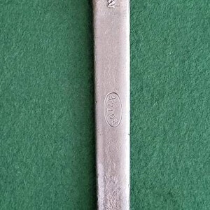 K&ouml;nnte beinhalten: Ein silberner Schraubenschl&uuml;ssel mit einer &Ouml;ffnung von 3,8 cm und dem Text "ROTA-R" am Griff.