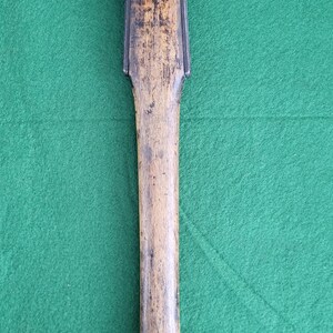 May include: A vintage axe with a wooden handle and a steel head. The axe head has a flat blade on one side and a pointed pick on the other. The wooden handle shows signs of wear.