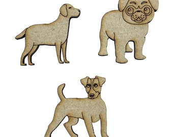 May include: Three wooden dog cutouts in a light brown colour. The cutouts include a Labrador, a pug with glasses, and a Jack Russell Terrier. The dogs are standing on a white background. Ideal for crafting or decorative purposes.