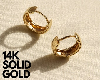 May include: Two gold hoop earrings with a textured design. The earrings are made of 14k solid gold.