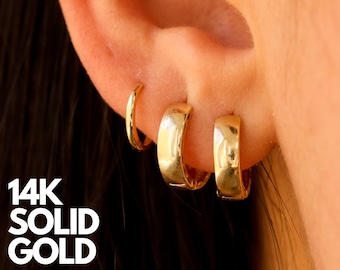 May include: Three gold hoop earrings of different sizes. The earrings are made of 14k solid gold. The text "14K SOLID GOLD" is visible in the image.