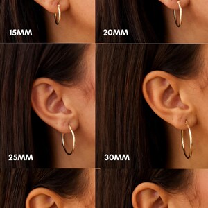 May include: Four pairs of gold hoop earrings in different sizes, 15mm, 20mm, 25mm, 30mm, 35mm, and 40mm, shown on a model's ear. The earrings are 2mm wide.