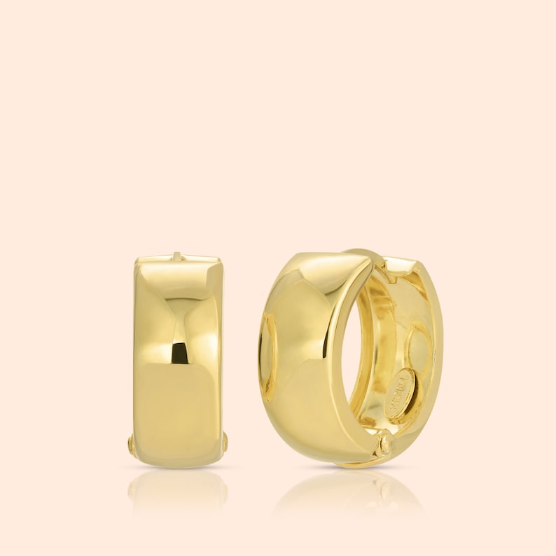 May include: A pair of gold hoop earrings. The earrings are smooth and have a polished finish.