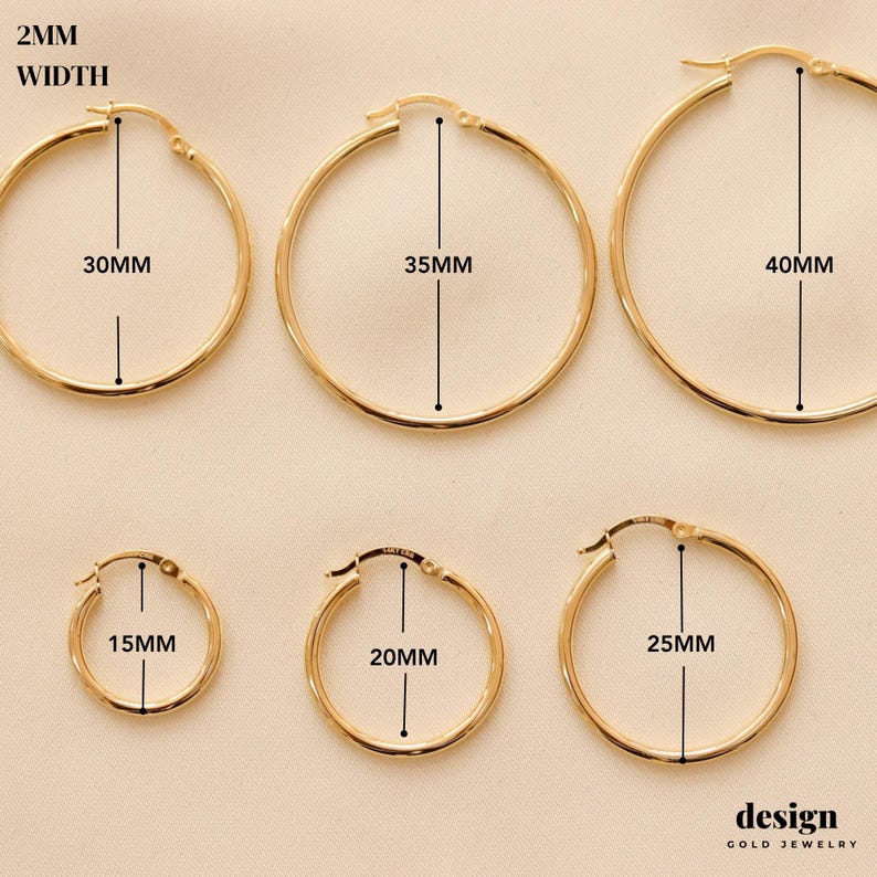 May include: Six pairs of gold hoop earrings in different sizes. The earrings are 2 mm wide and range in diameter from 15 mm to 40 mm. The earrings are labeled with their diameter in millimeters.