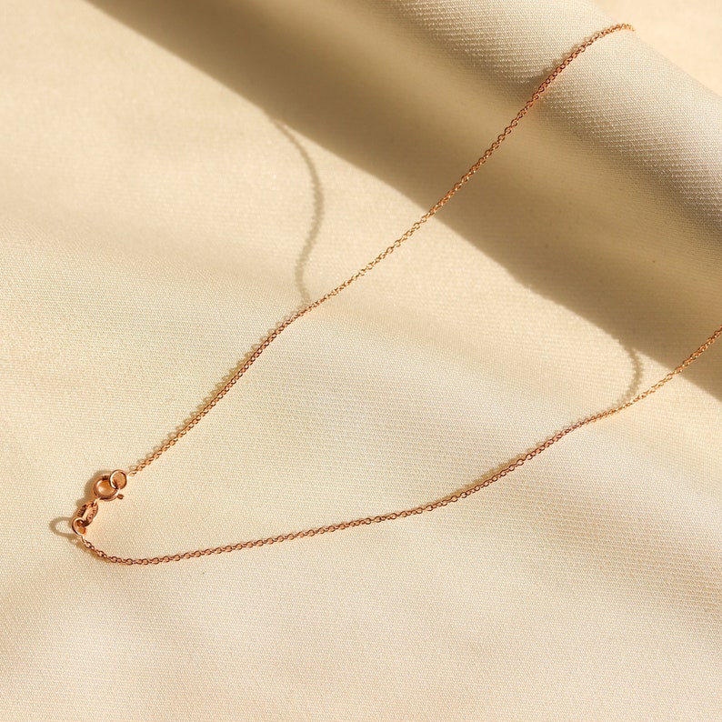 May include: A delicate rose gold chain necklace with a lobster clasp closure.