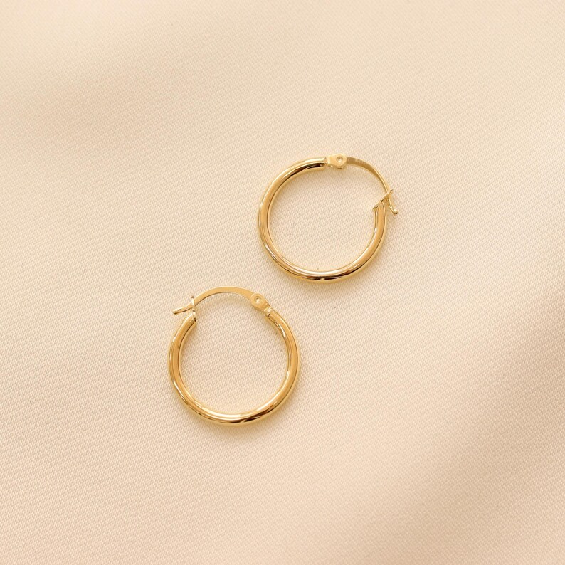 May include: A pair of gold hoop earrings. The earrings are simple and classic, and they would make a great addition to any jewelry collection.