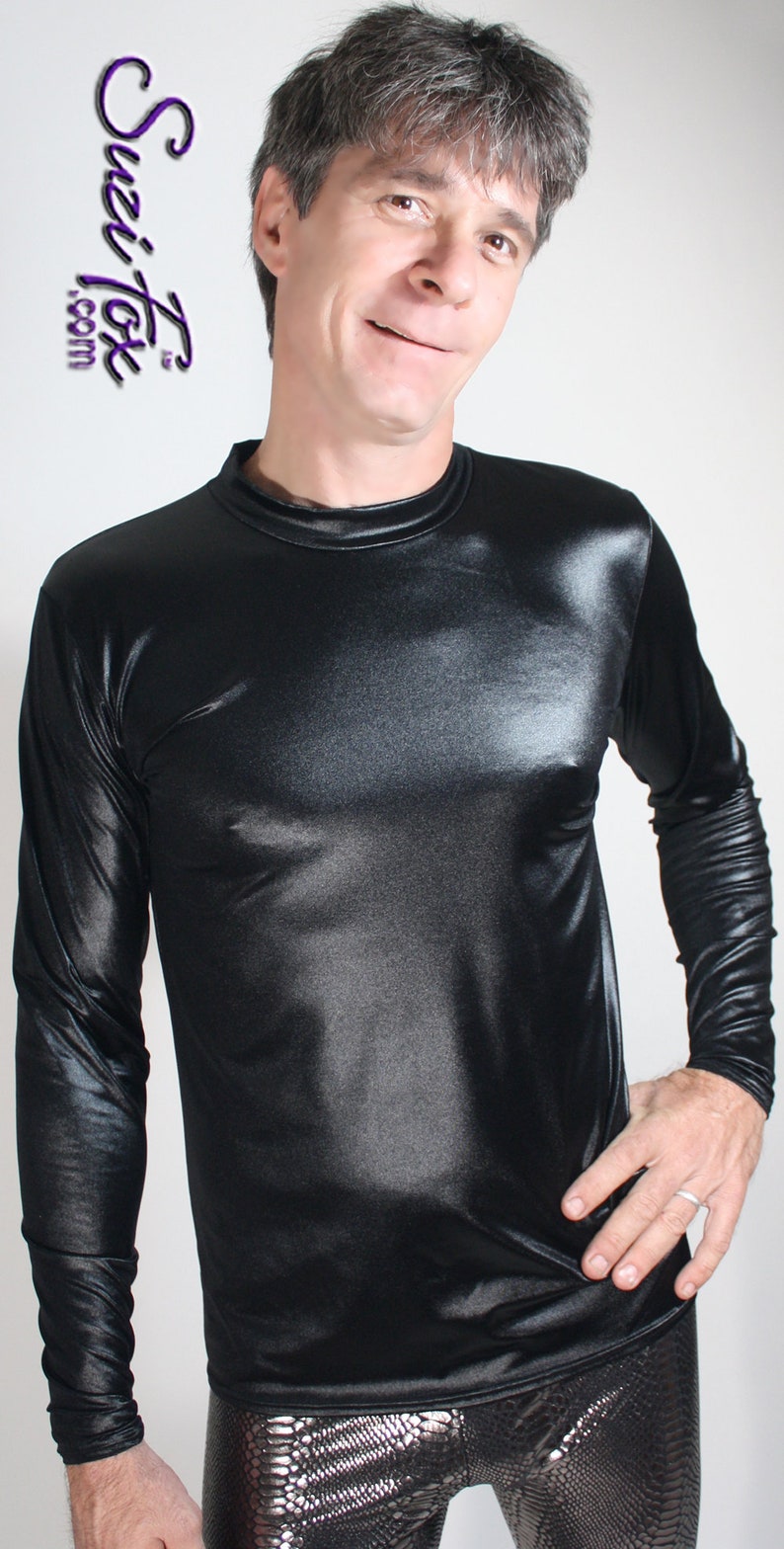 May include: A black long-sleeved shirt with a shiny, satin-like finish. The shirt has a crew neck and is worn over silver snake-skin patterned pants.