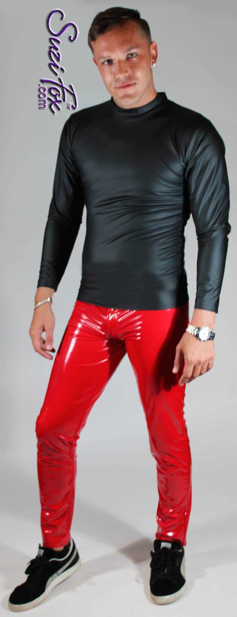 May include: A person wearing a black long-sleeved shirt and red pants. The shirt has a mock neck and the pants are shiny.