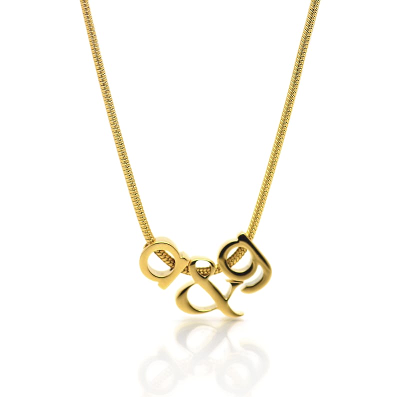 K&ouml;nnte beinhalten: Eine goldene Kettenkette mit einem Anh&auml;nger mit den ineinander verschlungenen Buchstaben "D&G".