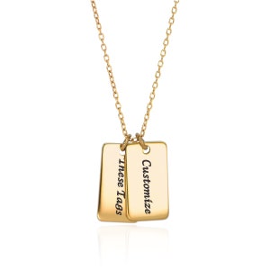 Könnte beinhalten: Goldkette mit zwei rechteckigen Anhängern. Die Anhänger sind mit dem Text "Anpassen" und "Diese Anhänger" graviert.