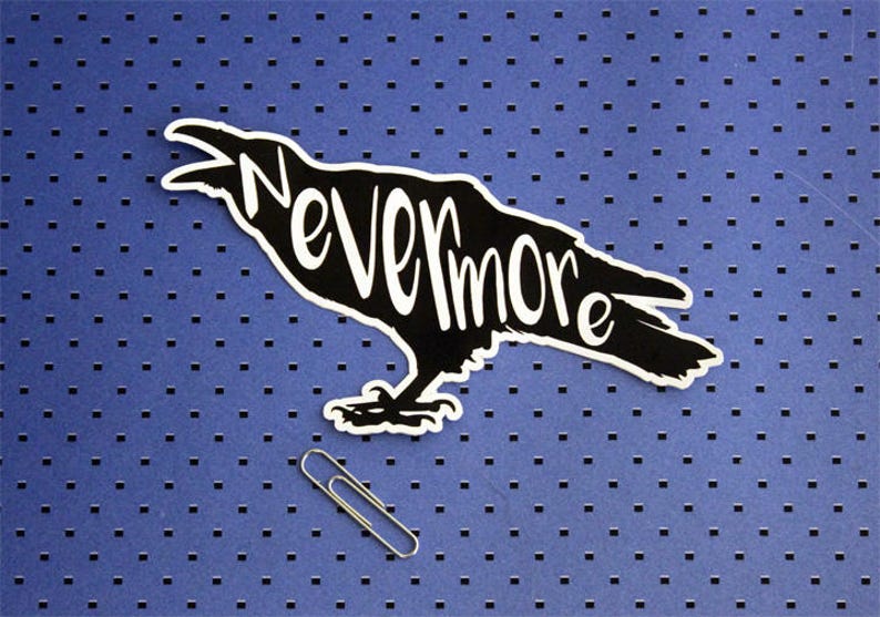 May include: Black silhouette of a raven with the word "Nevermore" written on its body. The raven is on a blue background with a repeating pattern of small squares.