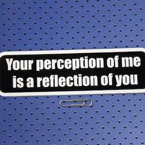 May include: White sticker with black text that reads "Your perception of me is a reflection of you".