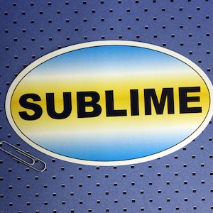 May include: A blue and yellow oval sticker with the word "SUBLIME" printed in black letters.