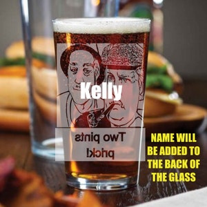 Puede incluir: Un vaso de pinta de vidrio transparente con una imagen en blanco y negro de dos hombres. El texto "Kelly" est&aacute; impreso en el vaso. El texto "Two pints!" est&aacute; impreso al rev&eacute;s en el vaso. El texto "NAME WILL BE ADDED TO THE BACK OF THE GLASS" est&aacute; impreso debajo del vaso.