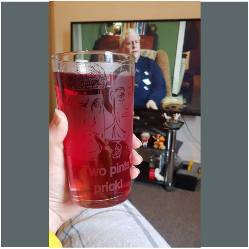 Puede incluir: Un vaso de vidrio transparente con una bebida roja en su interior. El vaso tiene un dise&ntilde;o grabado de tres caras y el texto "Two pints prick!"