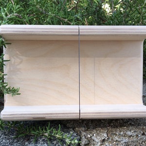 K&ouml;nnte beinhalten: Eine Holzkiste mit nat&uuml;rlicher Oberfl&auml;che und einer d&uuml;nnen schwarzen Linie in der Mitte. Die Kiste ist aus Sperrholz und hat eine leicht abgerundete Kante.