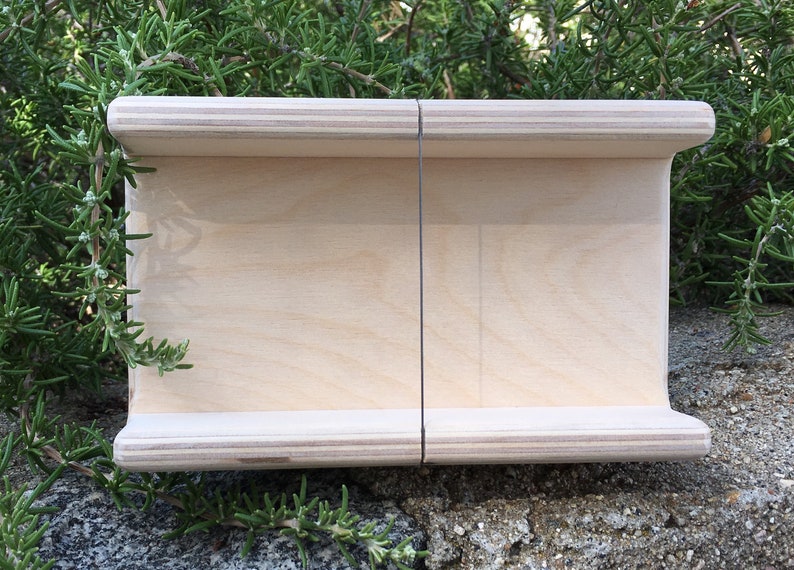 K&ouml;nnte beinhalten: Eine Holzkiste mit nat&uuml;rlicher Oberfl&auml;che und einer d&uuml;nnen schwarzen Linie in der Mitte. Die Kiste ist aus Sperrholz und hat eine leicht abgerundete Kante.