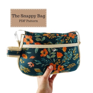 May include: A teal floral print bag featuring orange flowers and cream-coloured trim. The bag has a cream strap and the text "The Snappy Bag PDF Pattern" is displayed on a tan rectangle.