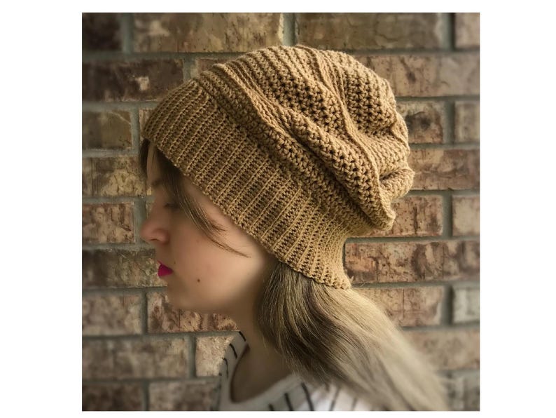 May include: A brown crocheted beanie hat with a slouchy fit. The hat is made with a textured stitch pattern.