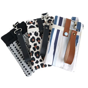 Puede incluir: Cuatro fundas para tel&eacute;fono diferentes con varios patrones y colores. Cada funda tiene una correa de mu&ntilde;eca y un cierre de cremallera. Los patrones incluyen lunares negros y blancos, estampado de leopardo, rayas azules y blancas y un dise&ntilde;o abstracto azul claro y blanco.